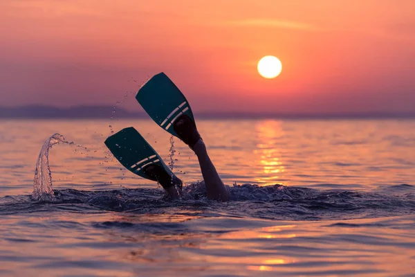 Buceador con aletas al atardecer sobre el mar — Foto de Stock