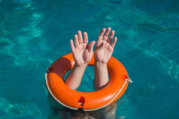 Manos de hombre y boya de vida en el agua. Servicio de ahogamiento y rescate con — Foto de Stock