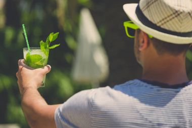 Mojito kokteyl açık havada tutan turist adam
