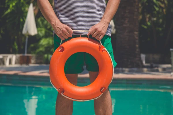ใกล้ชิดกับผู้ชายที่ถือ lifebuoy ที่ริมสระว่ายน้ํา — ภาพถ่ายสต็อก