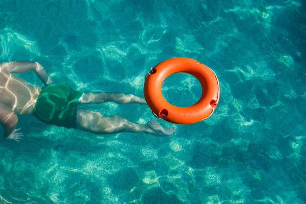 Boya salvavidas en el agua y el hombre buceando debajo de ella. Salvavidas y ahogamiento — Foto de Stock