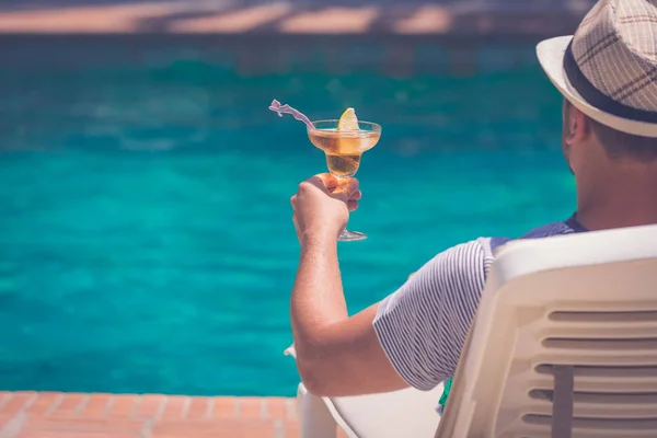 Hombre relajante junto a la piscina y sosteniendo copacabana co — Foto de Stock