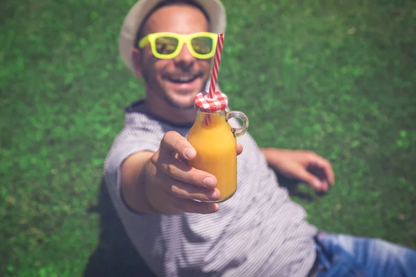 Hombre mostrando botella de jugo de naranja fresco — Foto de Stock