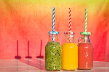 Taze sıkılmış meyve suları masada cam şişe