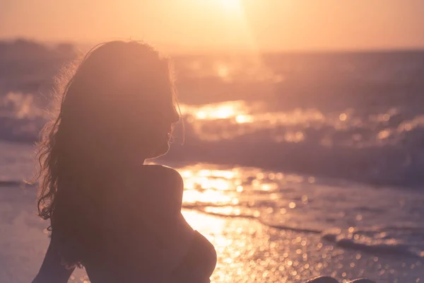 Young woman enjoying on beach at sunset — Stock Photo, Image