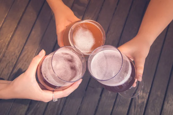 Grupo de amigos brindar com cerveja na mesa — Fotografia de Stock