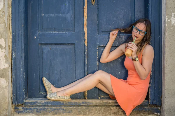 Genç erkek eski retro kapı önünde portakal suyu içme