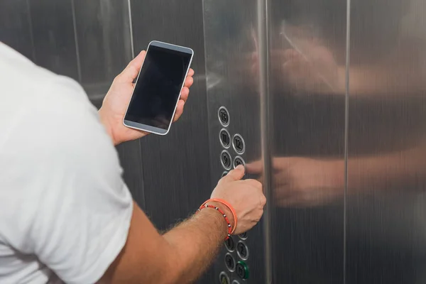 Чоловік тримає смартфон в ліфті — стокове фото