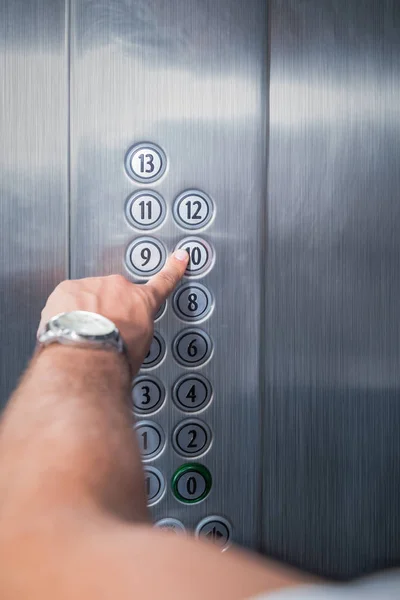 Homem pressionando o botão de dez andares no elevador — Fotografia de Stock