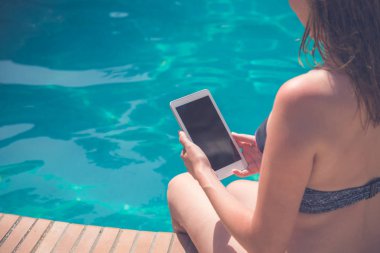 Havuz kenarında dijital tablet cihaz kullanarak erkek