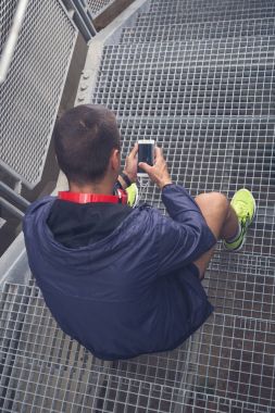 Merdivenlerde dinlenme ve smartphone kullanarak koşucu