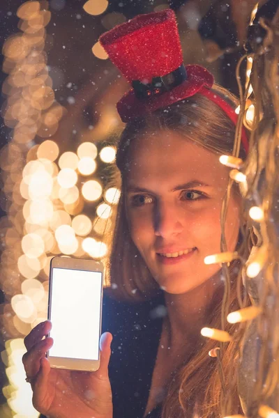 Жінка з порожнім екраном смартфон і різдвяні вогні прикраси. Концепція технології та свята . — стокове фото