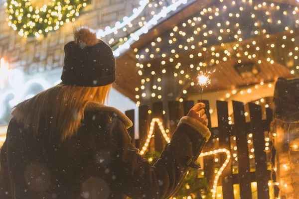 Жінка насолоджується Різдвом на свіжому повітрі з блискавками — стокове фото