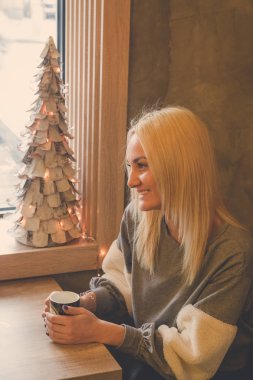 Kafede masada oturan ve çay tutan güzel kadın