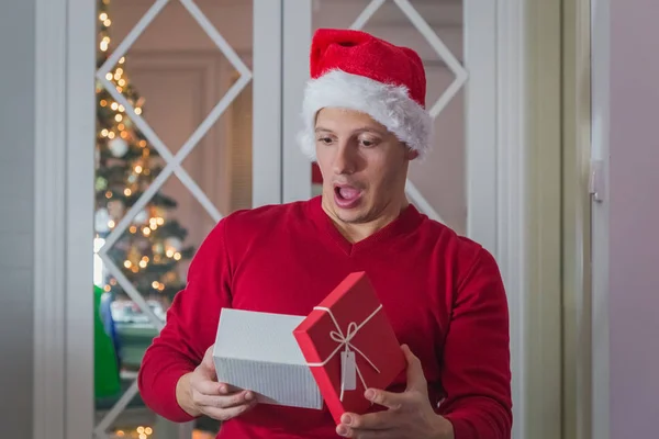 Hombre infeliz con sombrero de santa sorprendido con su regalo de Navidad — Foto de Stock