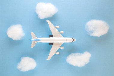 Mavi gökyüzü arka plan üzerinde uçak oyuncak ve bulutlar yüksek açılı görünüş