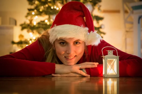 Mujer joven con sombrero de santa y linterna blanca. Concepto de Navidad — Foto de Stock