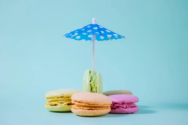 Papier parasol en macarons in verschillende kleuren. Ruimte voor de kopie — Stockfoto