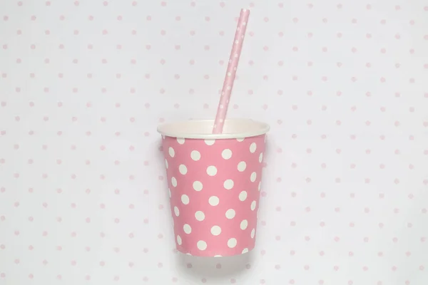 Tasse en papier rose uni avec paille à boire sur papier peint polka — Photo