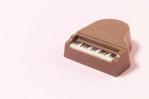 Miniatura piano barra de chocolate sobre fondo rosa. Espacio para copia . — Foto de Stock