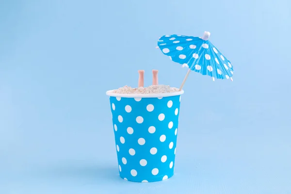 Papír poharat tele homokkal baba lábakkal és koktél napernyő. Nyári szezonban minimalista koncepció. — Stock Fotó