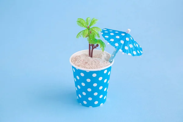 Copo de papel com ilha deserta e conceito de viagem guarda-chuva coquetel de papel . — Fotografia de Stock