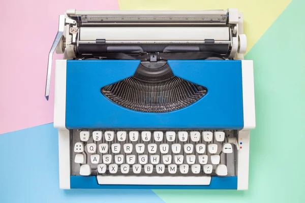 Pohled z vysokého úhlu retro psací stroj proti barevné pozadí. — Stock fotografie