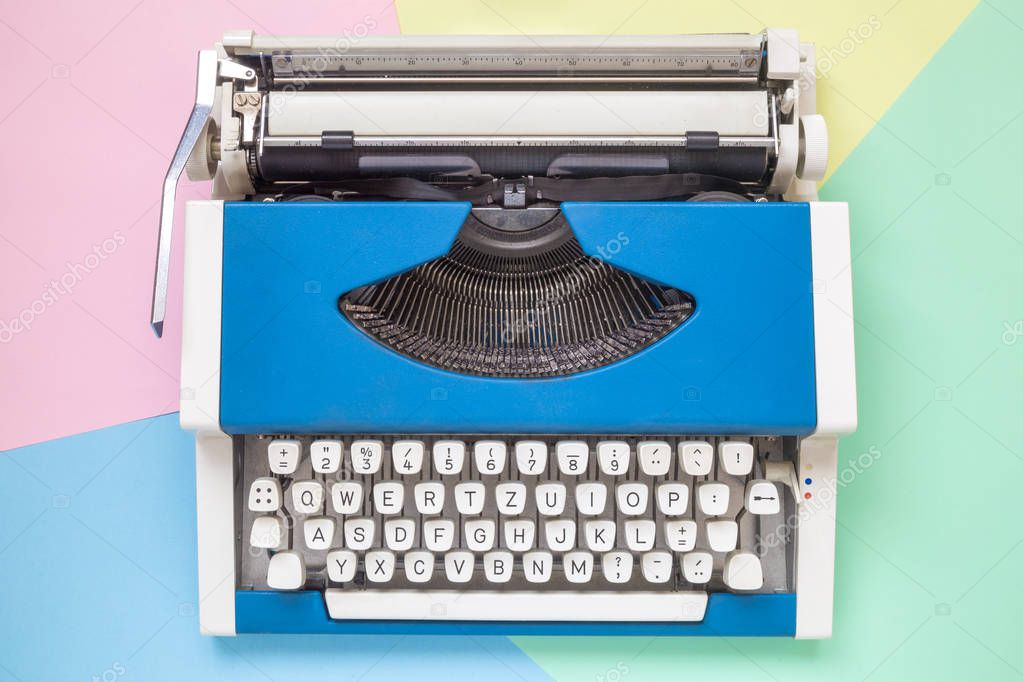 High angle view of retro typewriter against colorful background.