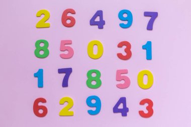 Çok renkli ahşap numaraları doku pastel gül arka plan minimalist kavramı üzerinde.