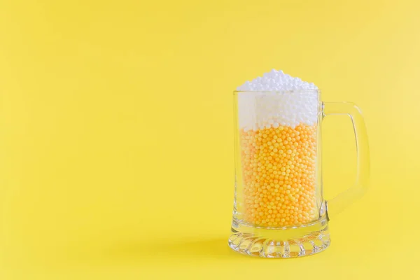 Кружка, полная желтых и белых пенных шариков в виде пива минималистская концепция . — стоковое фото