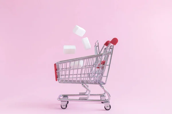Тележка с кубиками сахара, изолированная на розовой минималистской концепции . — стоковое фото