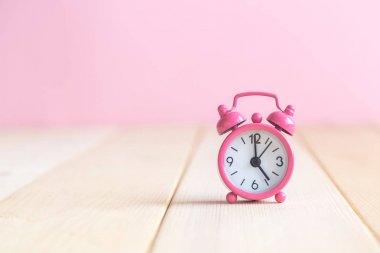 Çalar saat resepsiyon pastel pembe arka plan üzerinde yakın çekim.