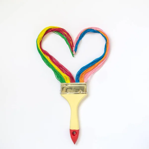Пензлик з різнокольоровою ниткою у формі серця концепція мінімалістичного мистецтва . — стокове фото