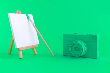 Fotoğraf makinesi boş sanat tuval ile yeşil ve arka plan fırça.