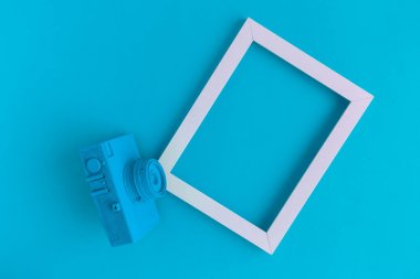 Düz mavi vintage kamera ve fotoğraf çerçeve arka plan yattı