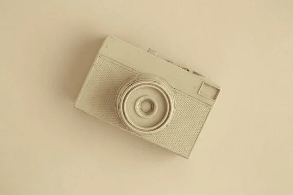 Flat lay of vintage film analog photo camera colored in beige surrealism artistic concept. — Stock Photo, Image