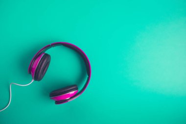 Yeşil arka plan yaratıcı müzik kavramı üzerinde kulaklık yüksek açılı görünüş.