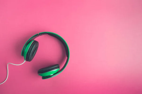 Gül arka plan yaratıcı müzik kavramı üzerinde kulaklık yüksek açılı görünüş.