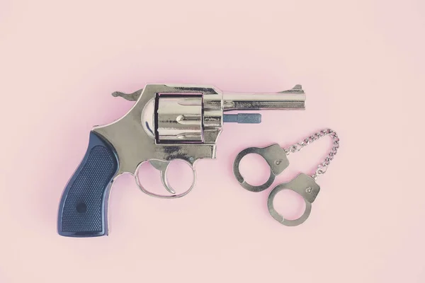 Hög vinkel syn på pistol och handfängsel. Polisen och brottsligheten koncept. — Stockfoto