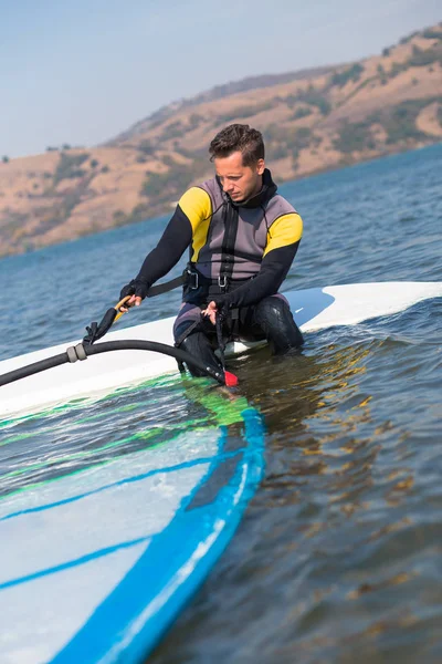 Jeune homme se préparant à la planche à voile . — Photo