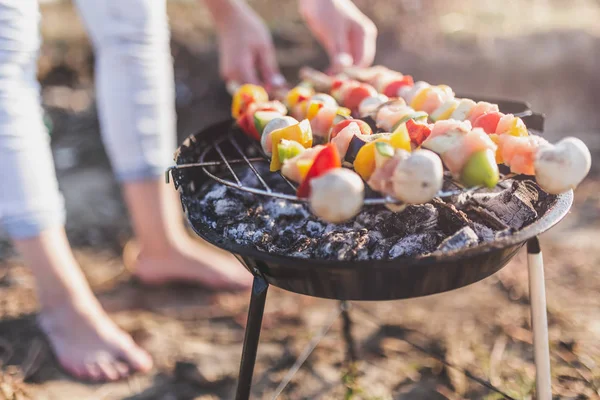 Gros plan de la jeune femelle préparant des brochettes de légumes et de poulet mélangées sur le barbecue à l'extérieur . — Photo