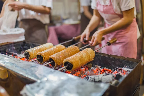 Préparation de gâteau de cheminée. Le gâteau de cheminée est rôti au-dessus du feu. Concept de nourriture de rue . — Photo