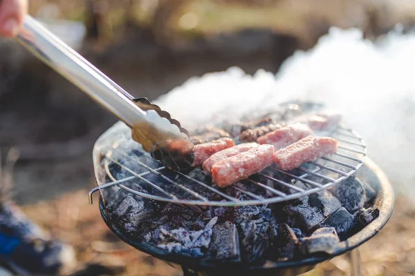 Gros plan de l'homme préparant des kebabs barbecue à l'extérieur. Concept camping et restauration . — Photo