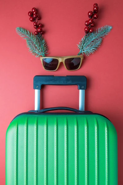 Resumen de viaje de Navidad hecho de equipaje y decoración de vacaciones aislado en rojo . — Foto de Stock