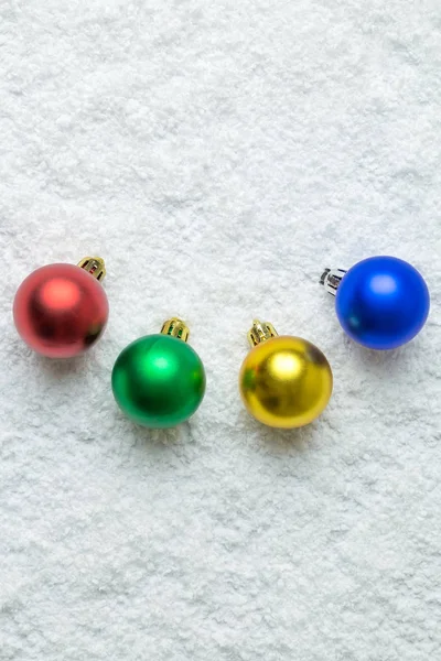 Flat lay of multicolored Christmas ball decoration on snow. Winter season and holiday concepts. — Stock Photo, Image