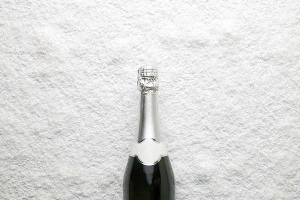 Pose plate de bouteille de champagne dans la neige concept créatif boisson minimale . — Photo