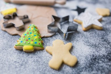 Şekerden, kesicilerden, hamurdan, renkli kremalı merdane ve bisküvilerden yapılmış Noel kurabiyeleri konsepti.