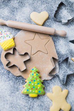 Şekerden, kesicilerden, hamurdan, renkli kremalı merdane ve bisküvilerden yapılmış Noel kurabiyeleri konsepti..