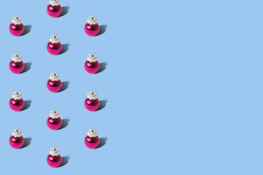 Pastel mavi arka planda pembe takılar Noel süslemeleri asgari yaratıcı tatil konsepti.