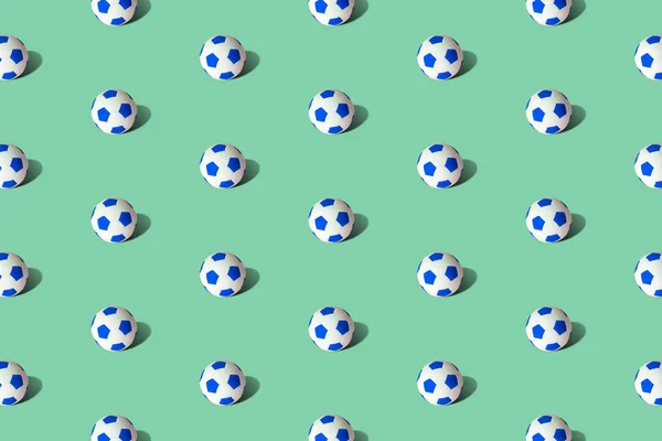 Pattern texture made of soccer balls abstract on pastel green.